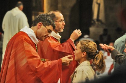 Les deux nouveaux évêques distribuent la communion aux fidèles. 