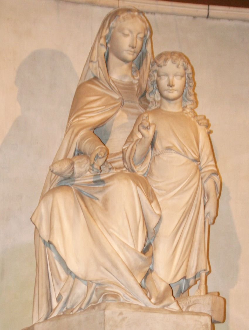 Notre-Dame du Travail. Marie assise tient sur ses genoux les outils de la fileuse. Près d'elle, Jésus adolescent tient un outil de charpentier reposant sur un bloc de bois. © C.D.A.S..